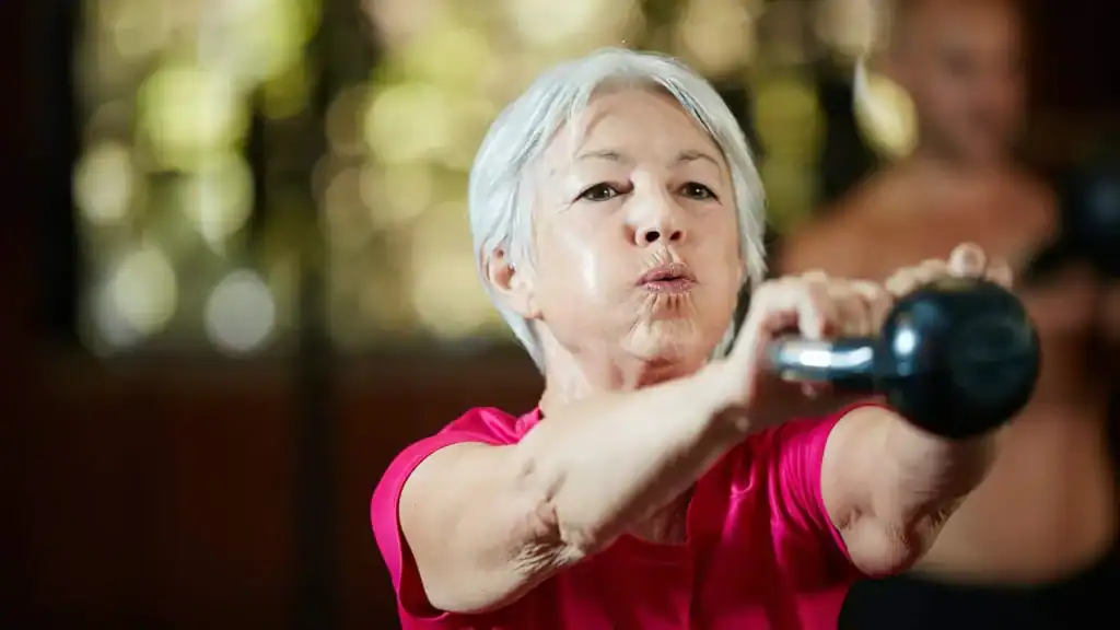 Toning Arms After 60: Empowering Womens Fitness Through Effective Weight Training 1 Older woman doing weight training Buckinghamshire to help her strength and longevity