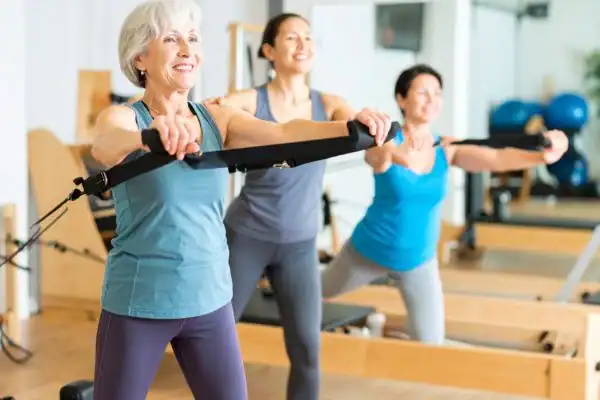 Toning Arms After 60: Empowering Womens Fitness Through Effective Weight Training 2 older woman doing weight training Buckinghamshire and resistance in the gym to tone upper arms