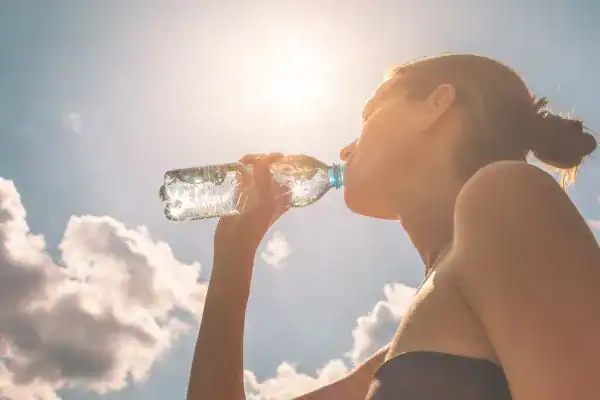 Hydration: The Secret Ingredient for a Toned Stomach and Enhanced Fitness 3 Image of woman drinking water to hydrate Buckinghamshire after run.