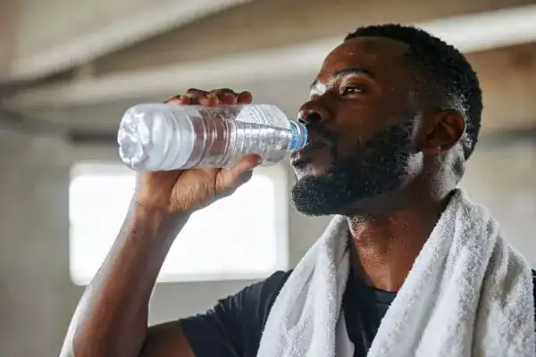Hydration: The Secret Ingredient for a Toned Stomach and Enhanced Fitness 1 Image of man drinking water to improve hydration Buckinghamshire after work out.